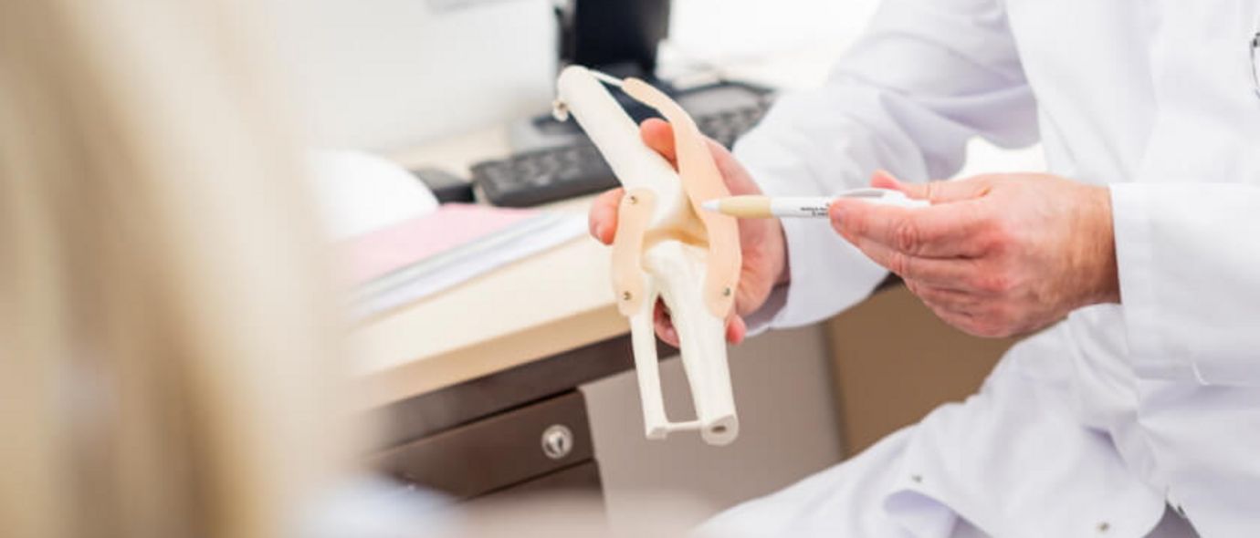 Arzt erklärt Patienten Gelenkfunktion anhand eines Gelenkmodells