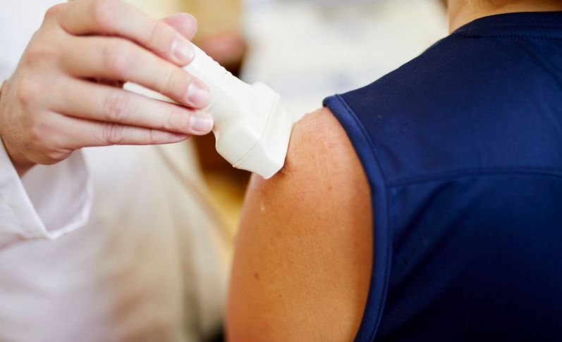 Arzt untersucht die Schulter eines Patienten mit Ultraschall
