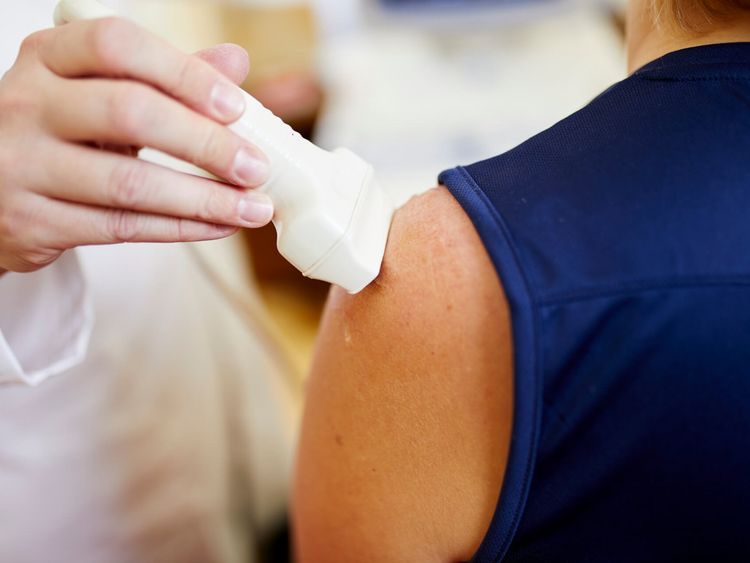 Arzt untersucht die Schulter eines Patienten mit Ultraschall