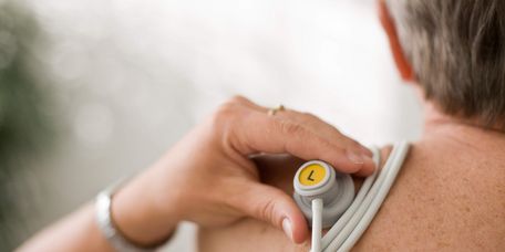 Pflegekraft bereitet Patienten auf EKG vor