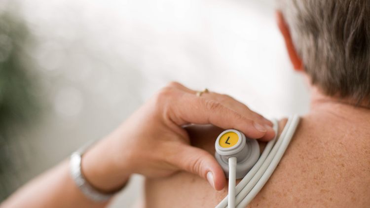 Pflegekraft bereitet Patienten auf EKG vor