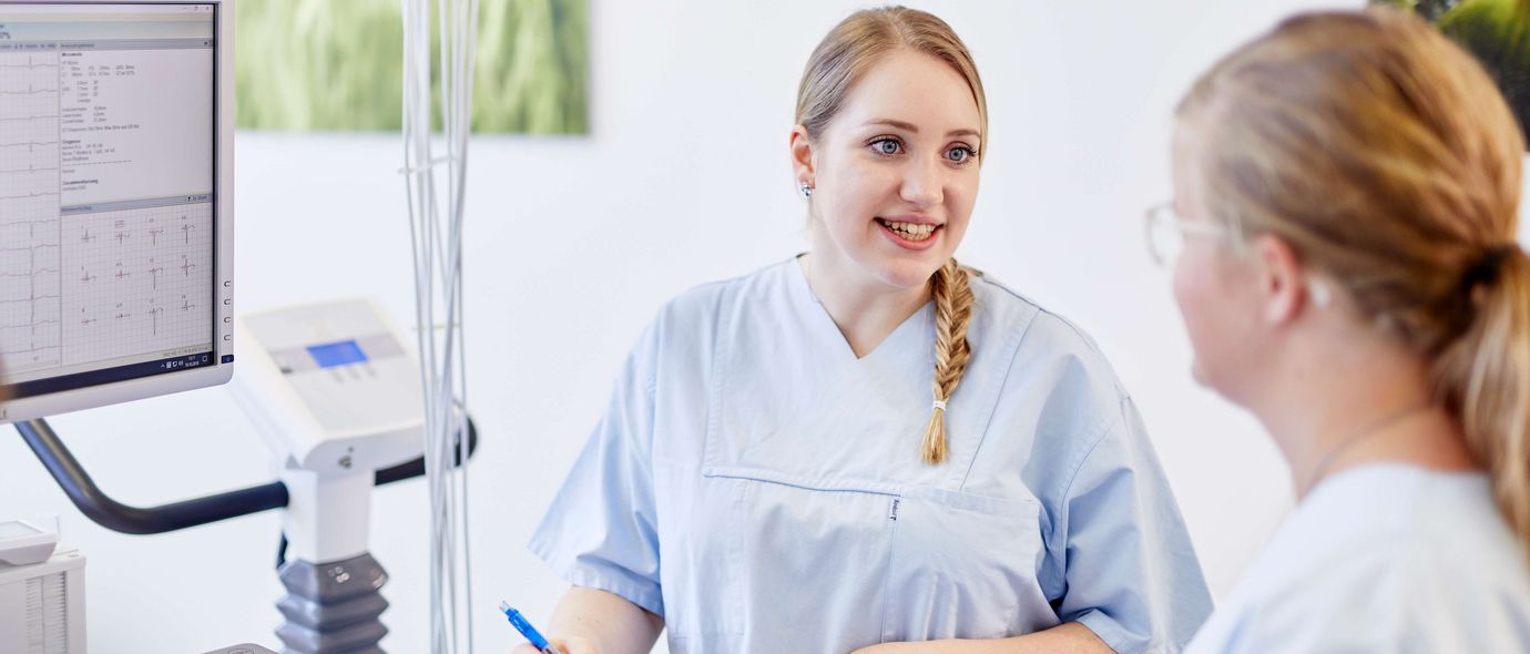 Medizinische Fachangestellte spricht mit Patientin