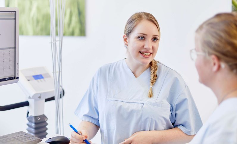 Medizinische Fachangestellte spricht mit Patientin