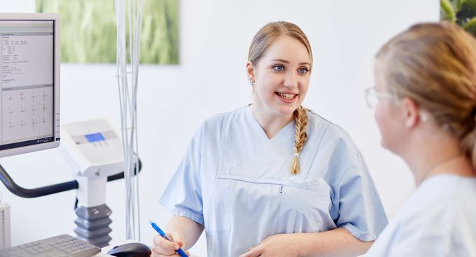 Medizinische Fachangestellte spricht mit Patientin