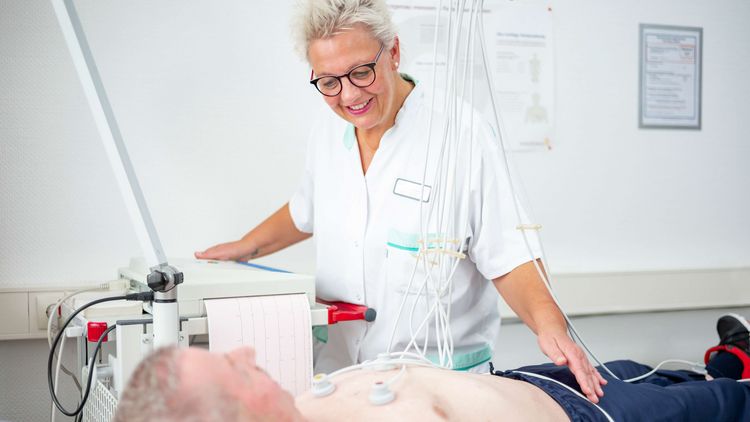 Pflegekraft bereitet Patienten auf EKG vor